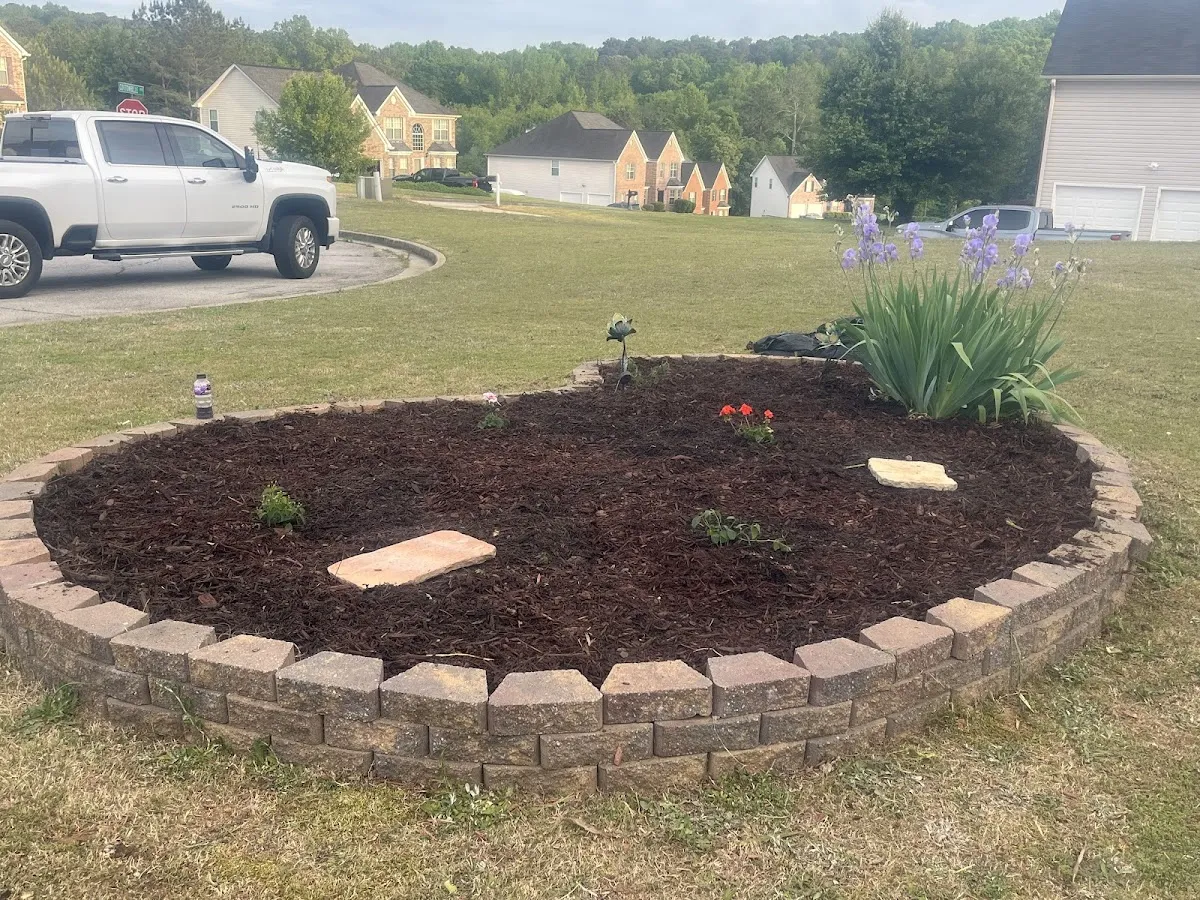 Stone-ringed mulch island bed, freshly planted and edged